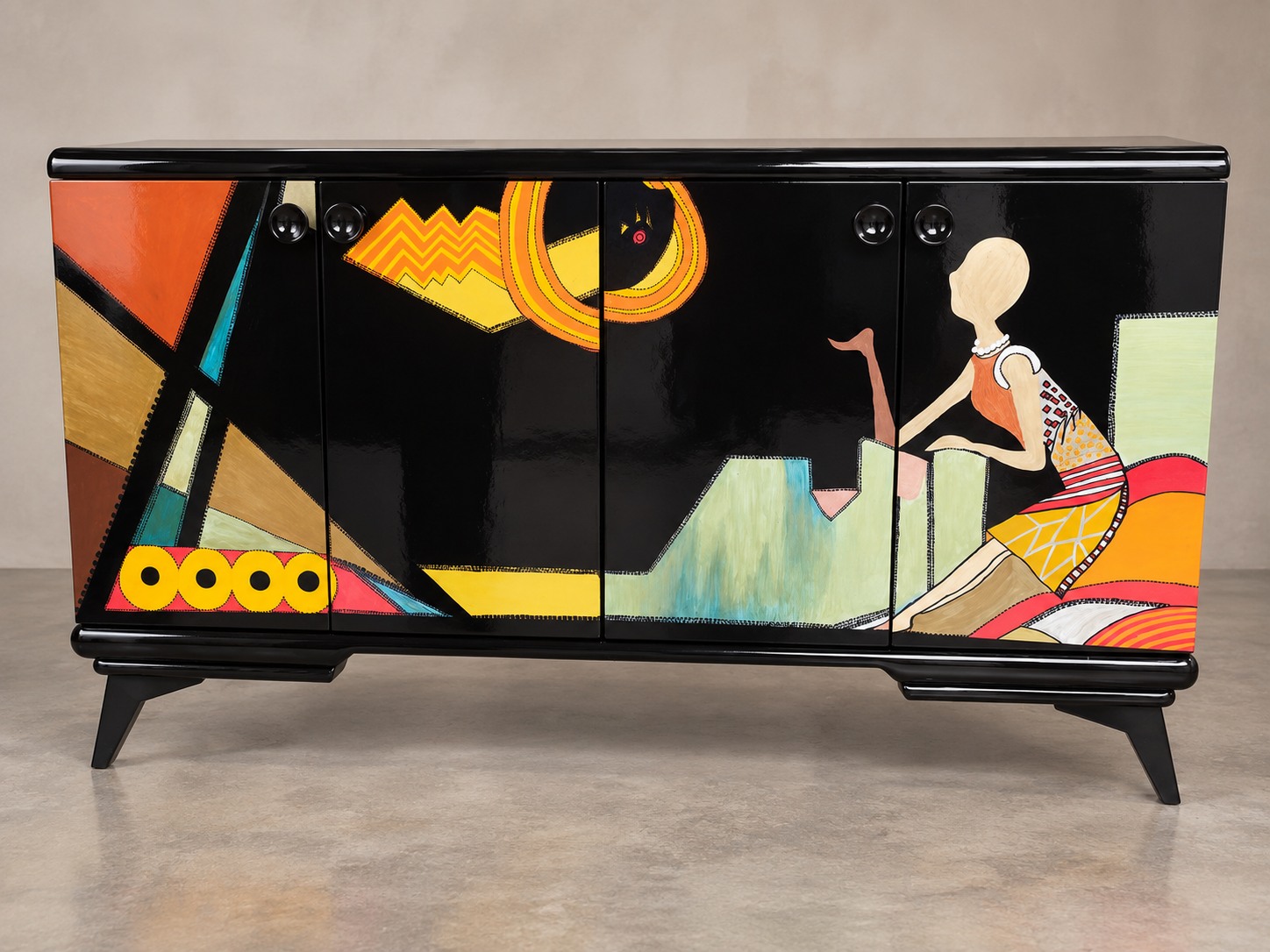 A vivid figurative and geometric composition stretches across glossy black doors. Bright colour and a sculptural silhouette make this sideboard a statement in its own right.