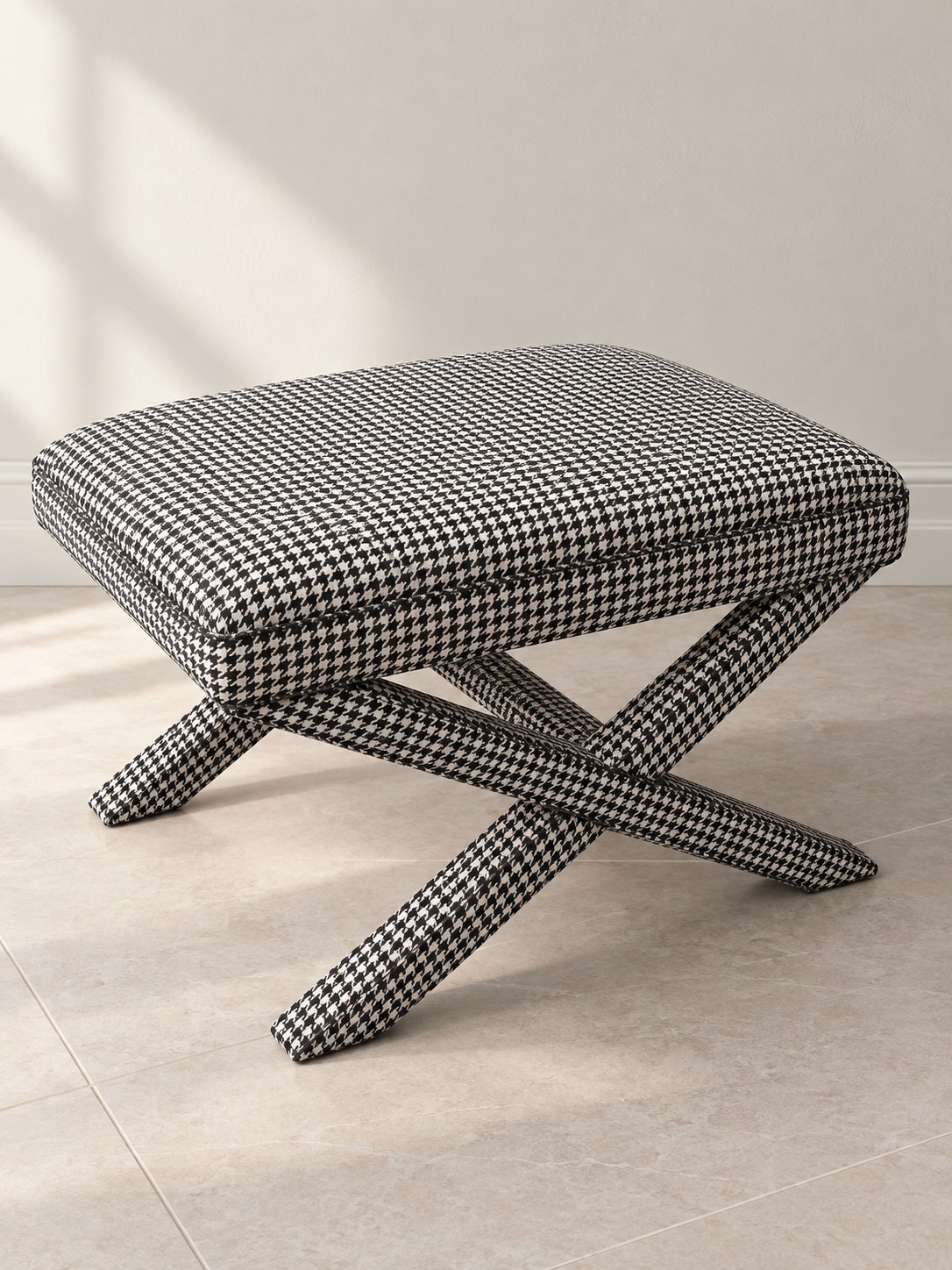 A classic black and ivory houndstooth pattern covers both the cushioned seat and crossing legs. A compact accent with a bold graphic presence.