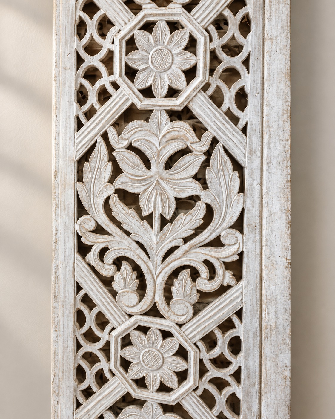 Openwork floral motifs and a distressed ivory finish turn this decorative panel into a study in texture. Light and shadow give the intricate pattern a gentle sense of depth.