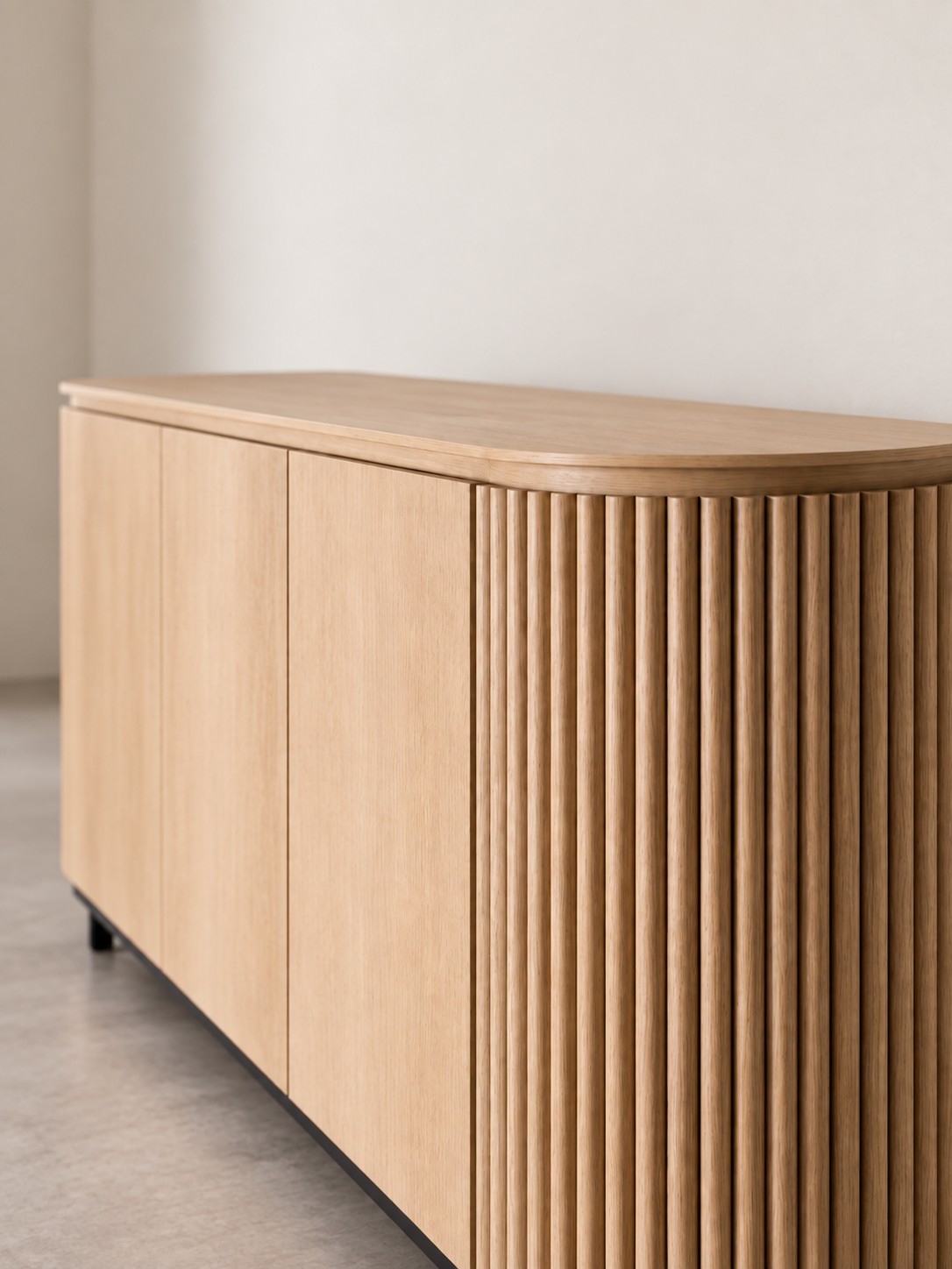 A pale wood finish, curved edges and fluted detailing bring a gentle rhythm to this sideboard. Clean door fronts balance the textured end panel.