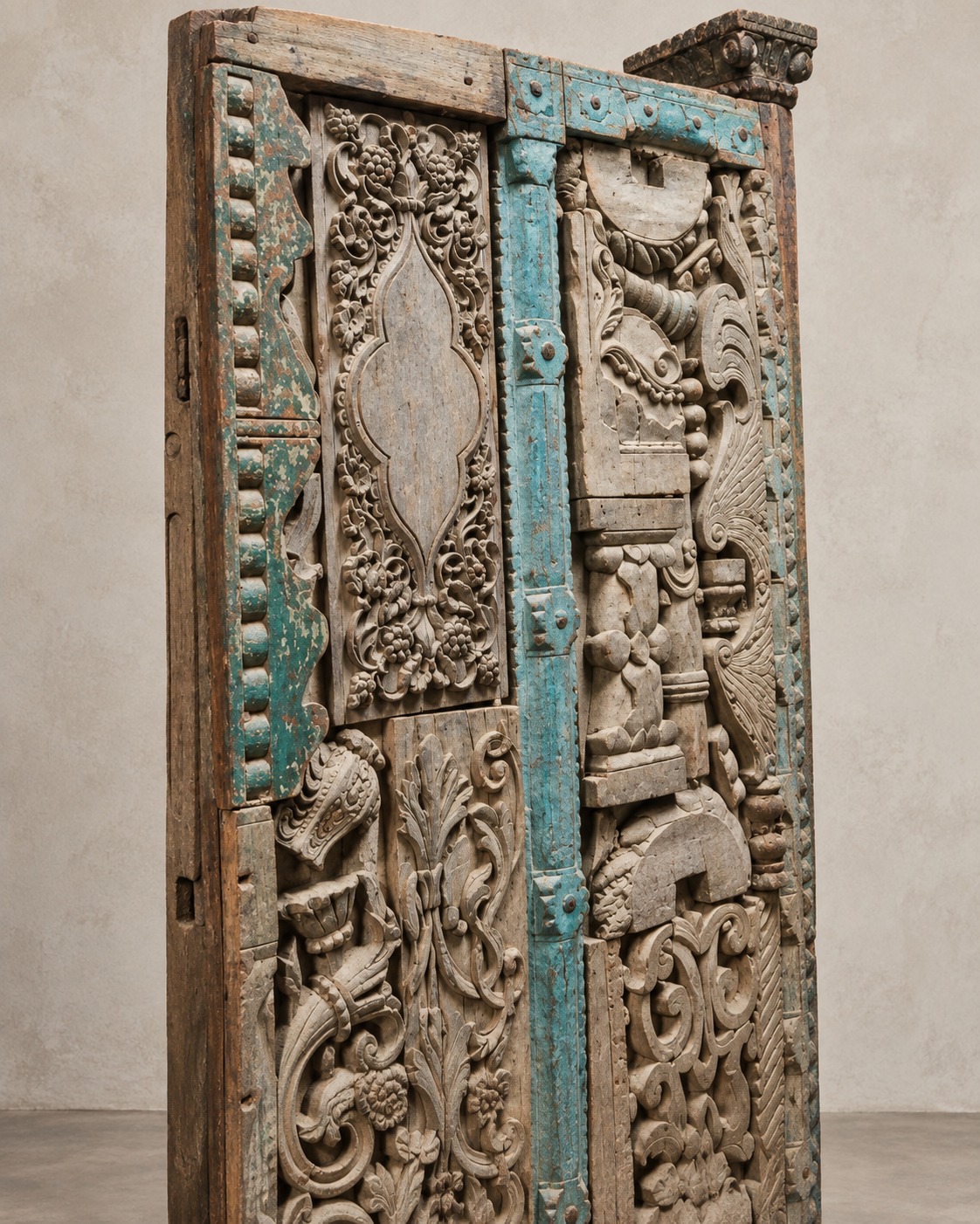 Layered carvings, weathered wood tones and touches of turquoise create a richly textured statement. The varied motifs bring a sense of character and visual interest to an understated setting.
